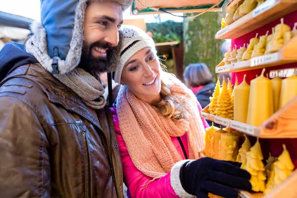 A couple in a Christmas market picking candles
