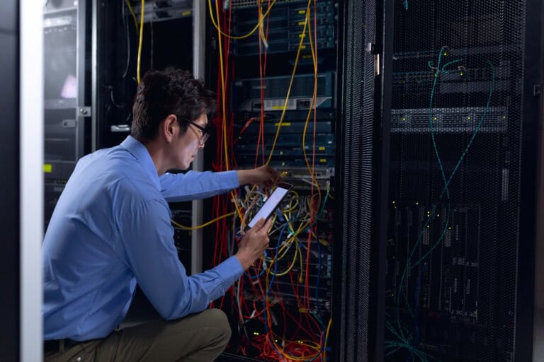 A male engineer in a server room in the concept of 'how to pack office it equipment and electronics'.
