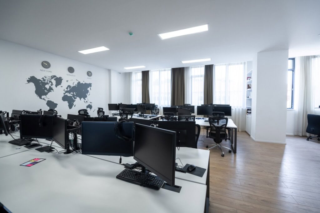 An open office plan filled with multiple desktops