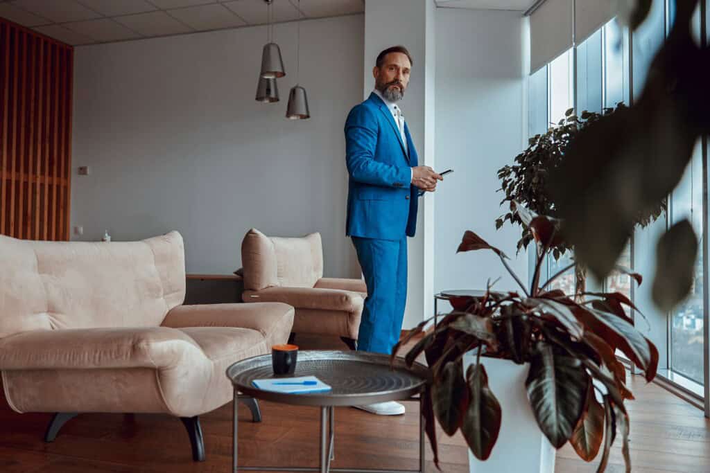 A stylish man standing in the lobby of their new office after the relocation