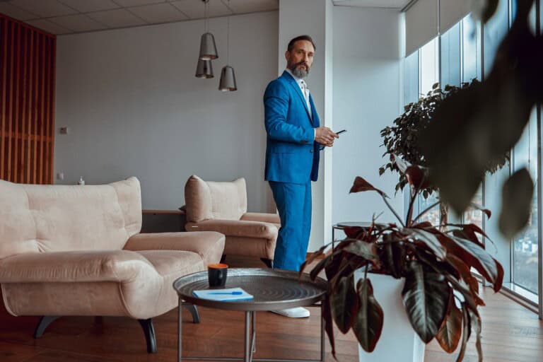 A stylish man standing in the lobby of their new office after the relocation