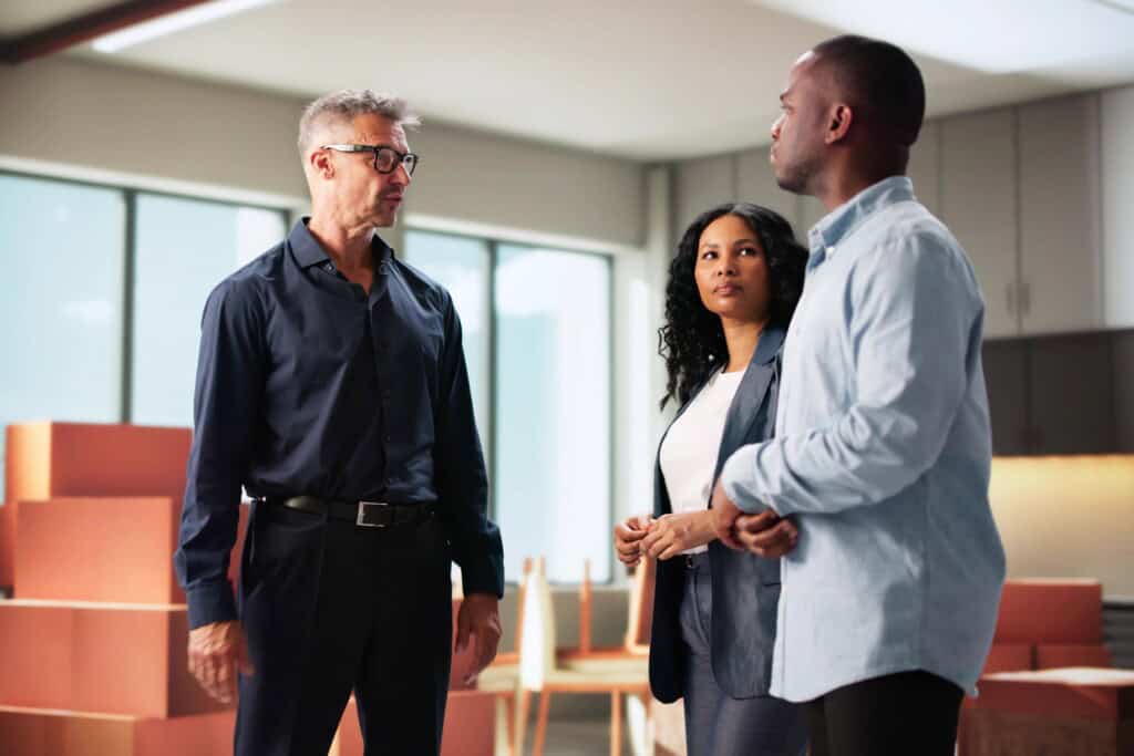 Professionals standing in their new office while surrounded by moving boxes